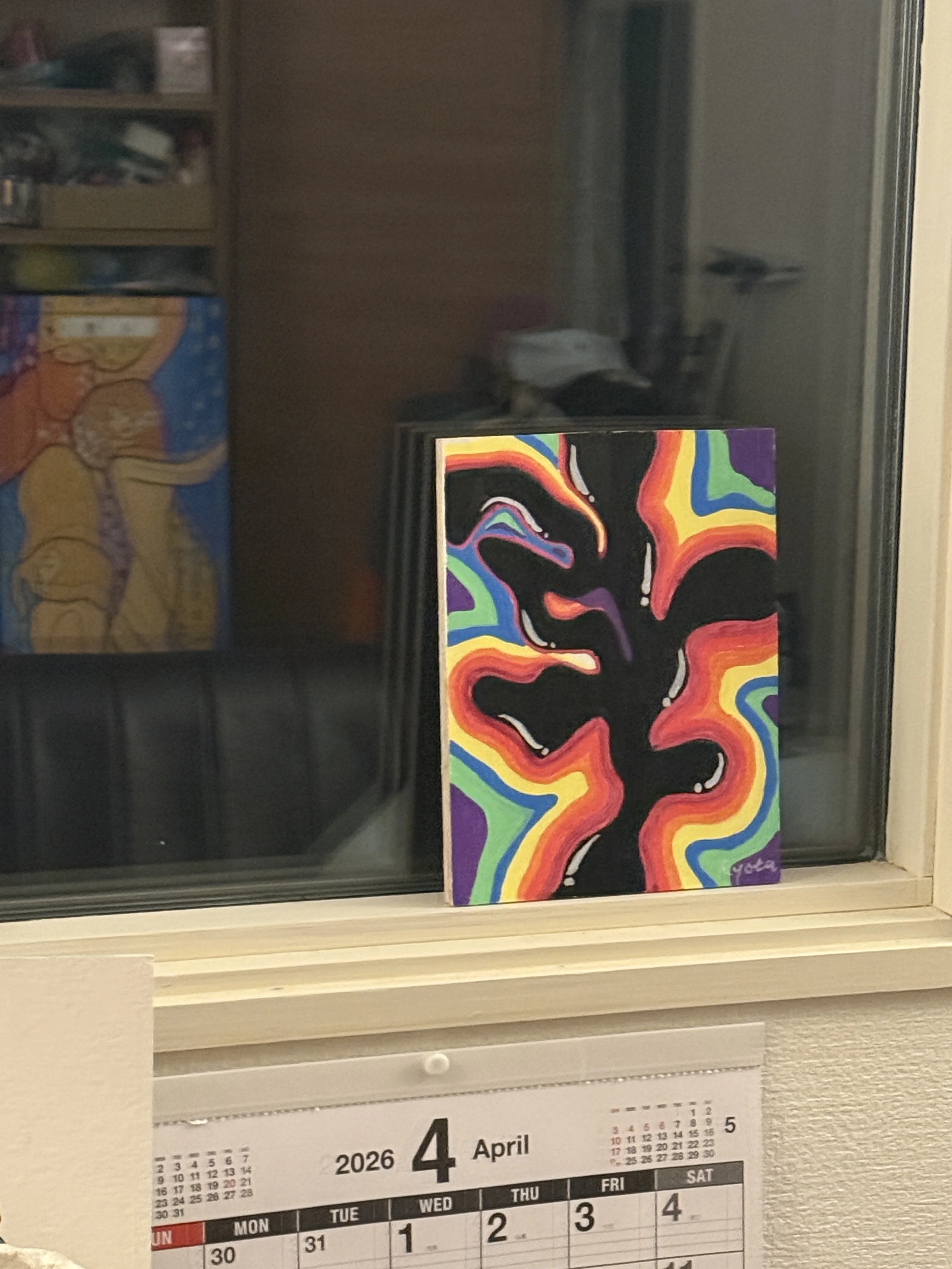 colorful painting by the window above an April calendar